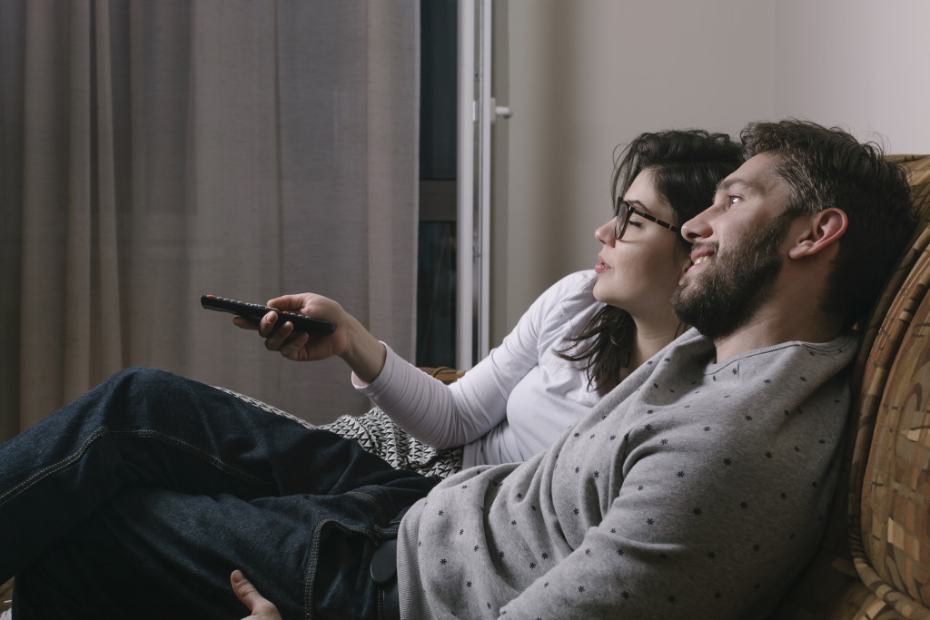 Cute couple changing channels on TV